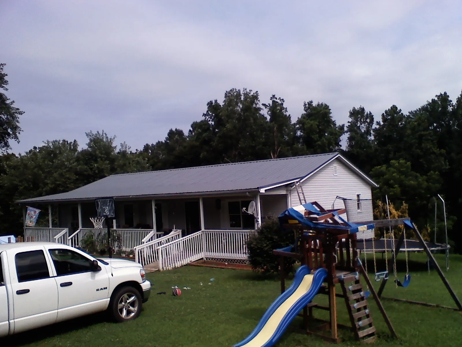 Dark metal roof on a country home with a full length front porch in Middlesex